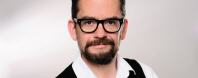Portrait Achim Happel mit Bart und Brille